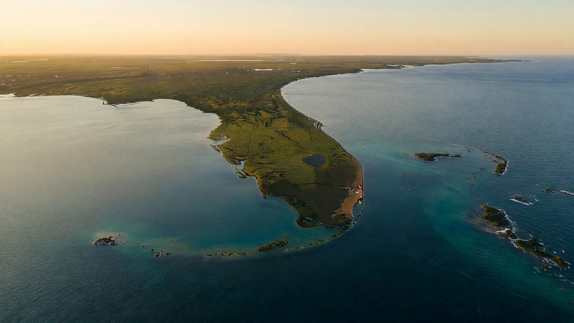 Aérea editorial de la península de Florida y el Golfo de México a la hora dorada — dos costas, sin etiquetas, sin personas.